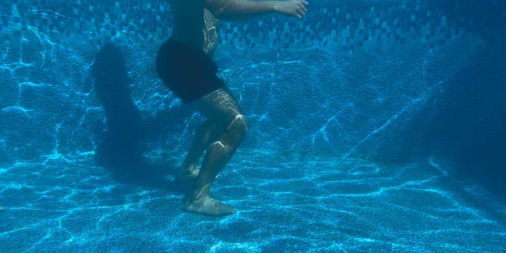 Man demonstrating aqua therapy exercise, Hip Flexion & Extension. Under water angle.